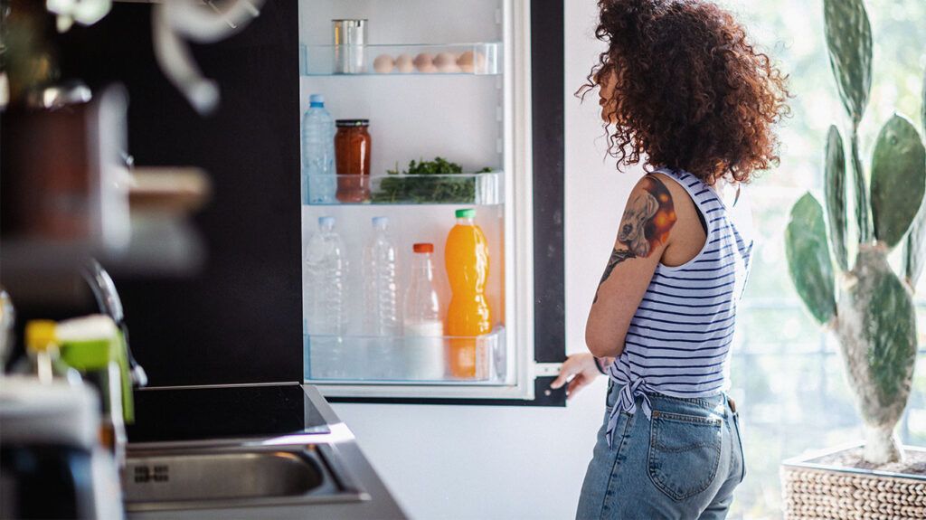 A person is looking in a fridge.