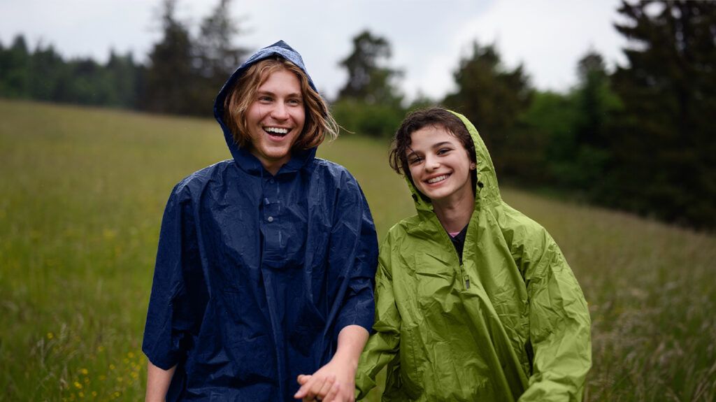 A couple walking in the rain and smiling. -3