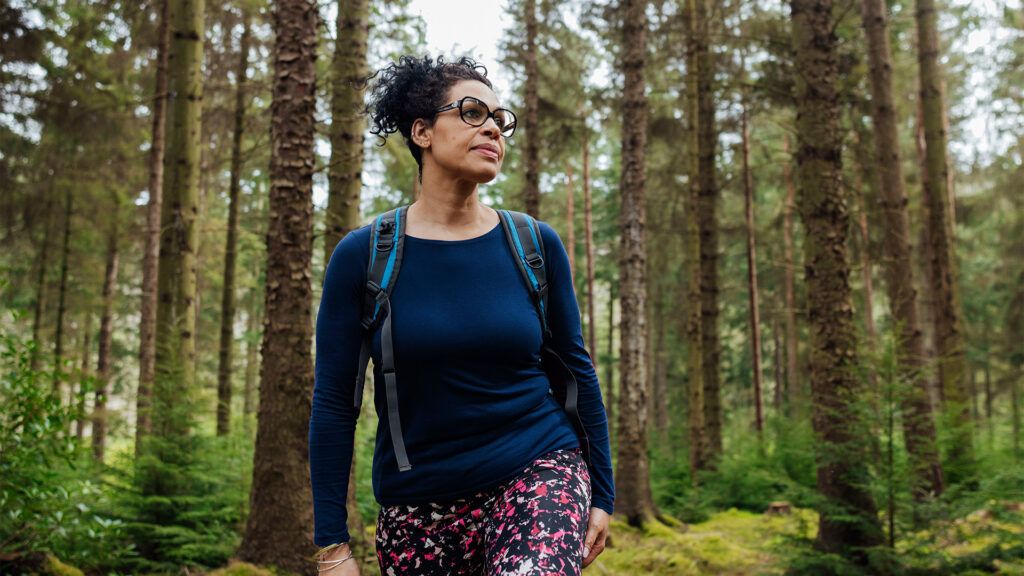 A woman with a backpack walks in the woods