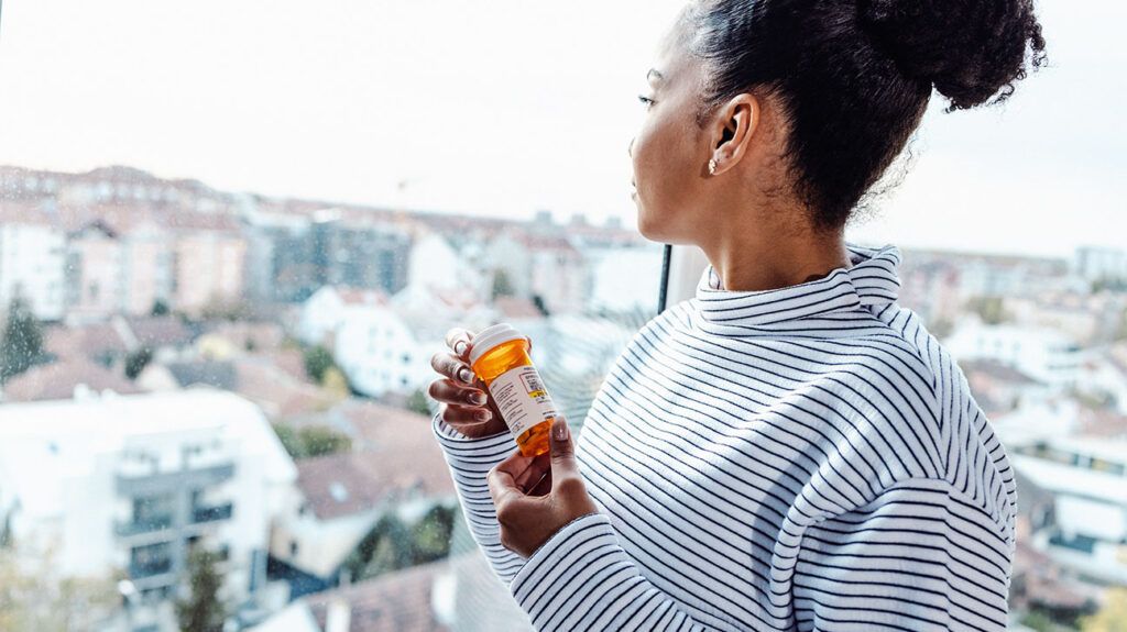 A woman holding a container of drugs that may affect female fertility. -2