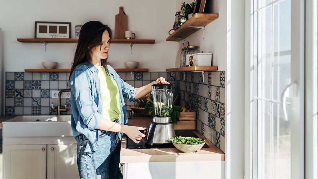 A person who may have anemia blending a smoothie or juice in a kitchen.-2