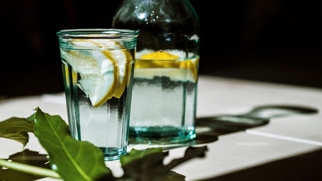 a glass of lemon water on a table
