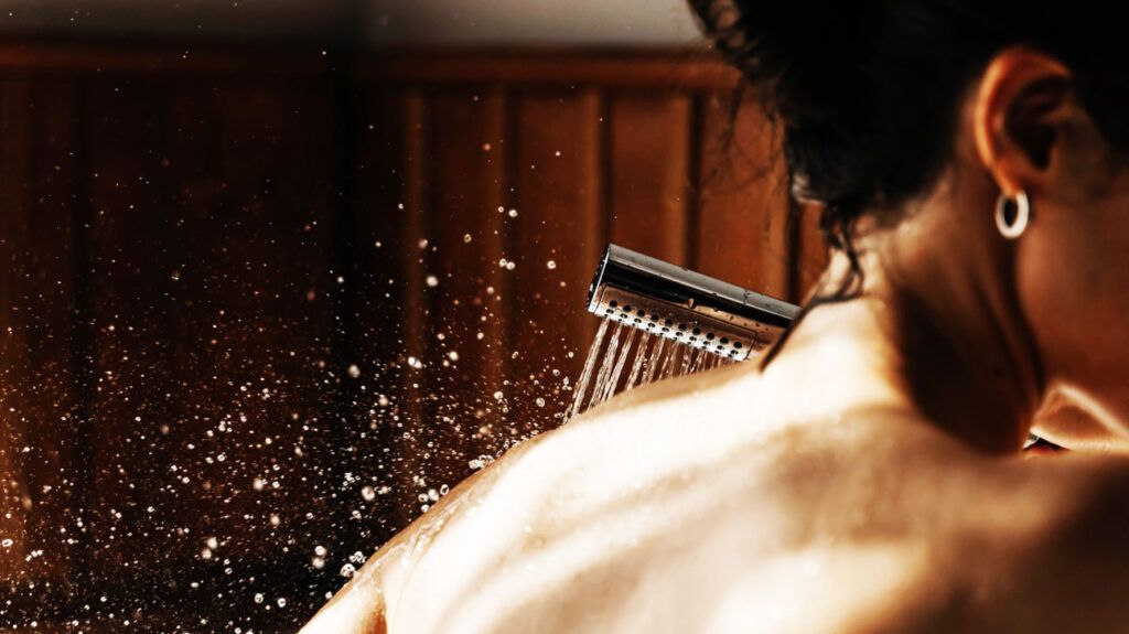 Closeup of a person showering their back