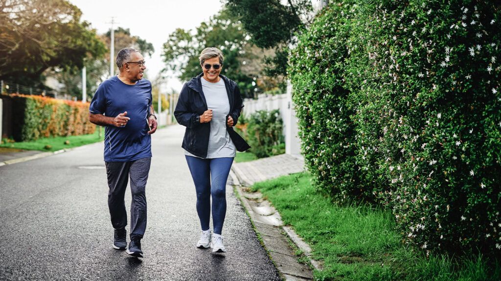 Two older adults jogging outdoors