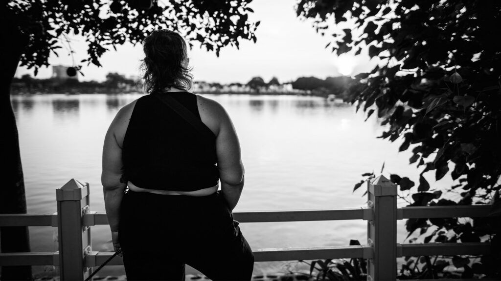A woman with obesity gazes out over a lake