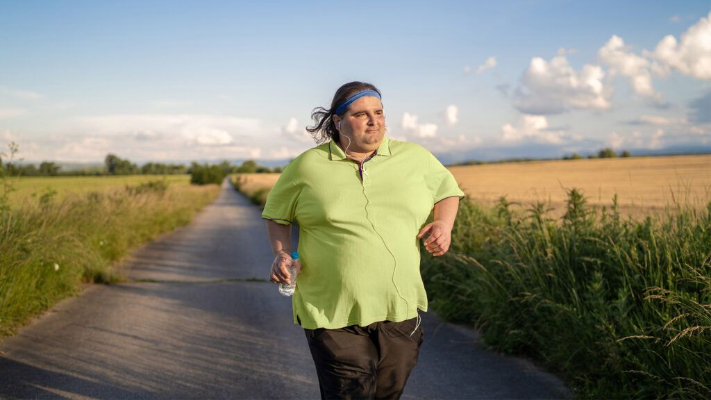 man with obesity running on country road
