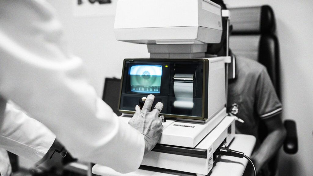 A doctor using equipment to examine the eye of a patient.