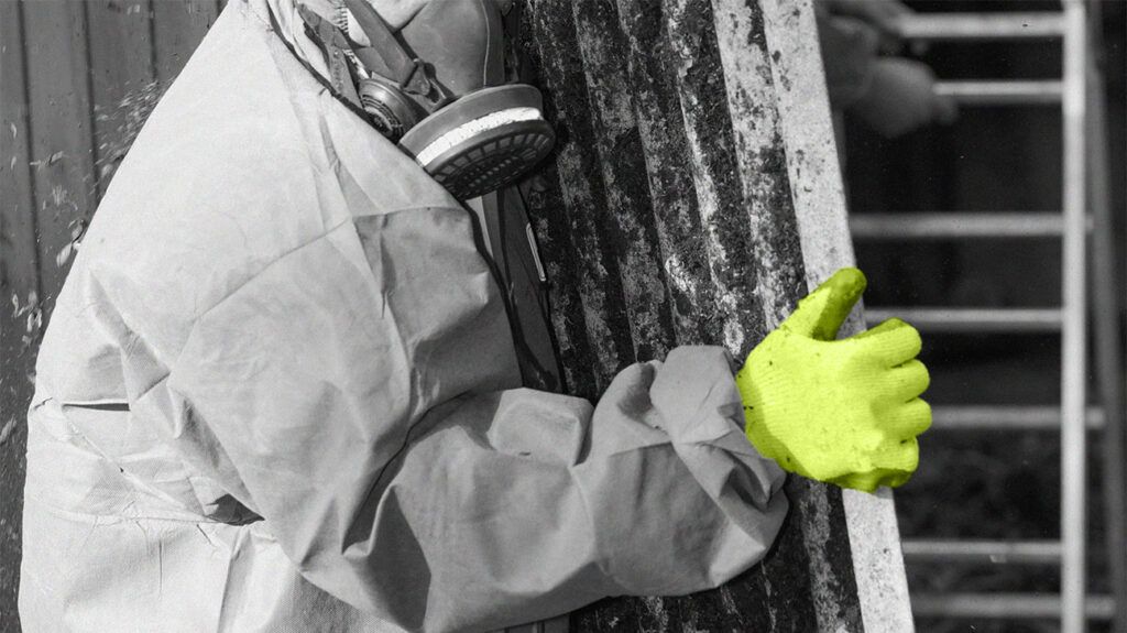 A person wearing protective clothing to remove asbestos from a building 1