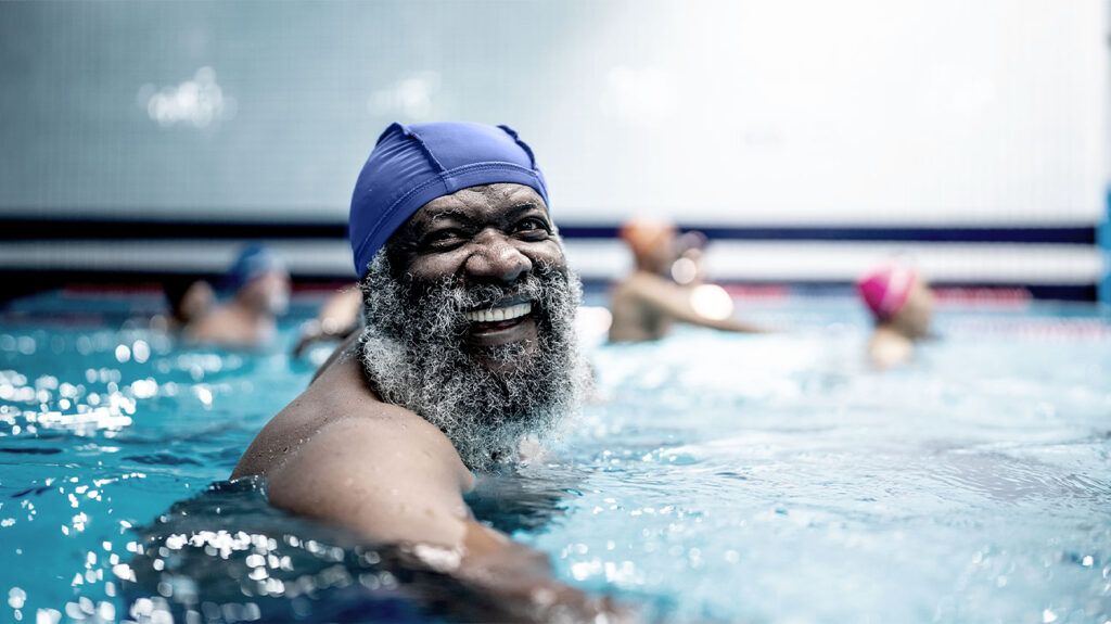 smiling older black man with long beard in swimming pool