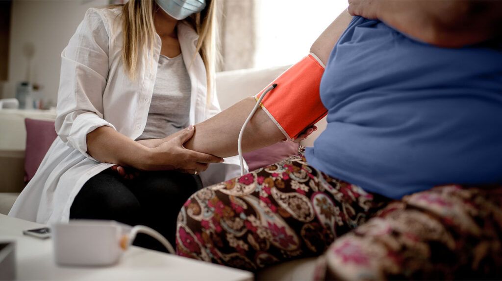A medical professional checks a woman's blood pressure