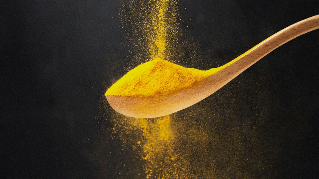 Turmeric on a wooden spoon.