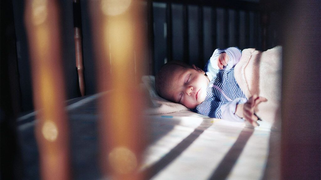 A sleeping newborn baby in a crib.