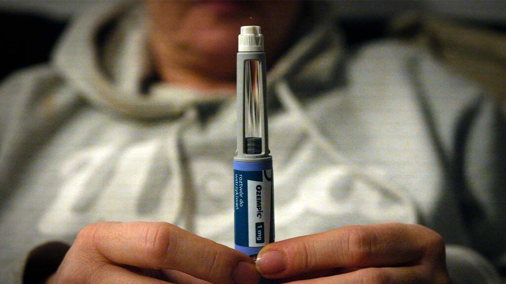 Close up of female holding an Ozempic injectable pen