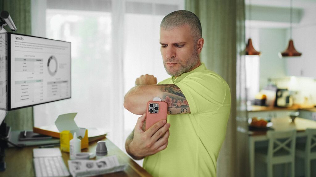 A younger man checks his blood sugar levels at home