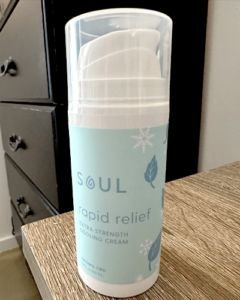 soul cbd rapid relief cream bottle on countertop with sample on wrist.
