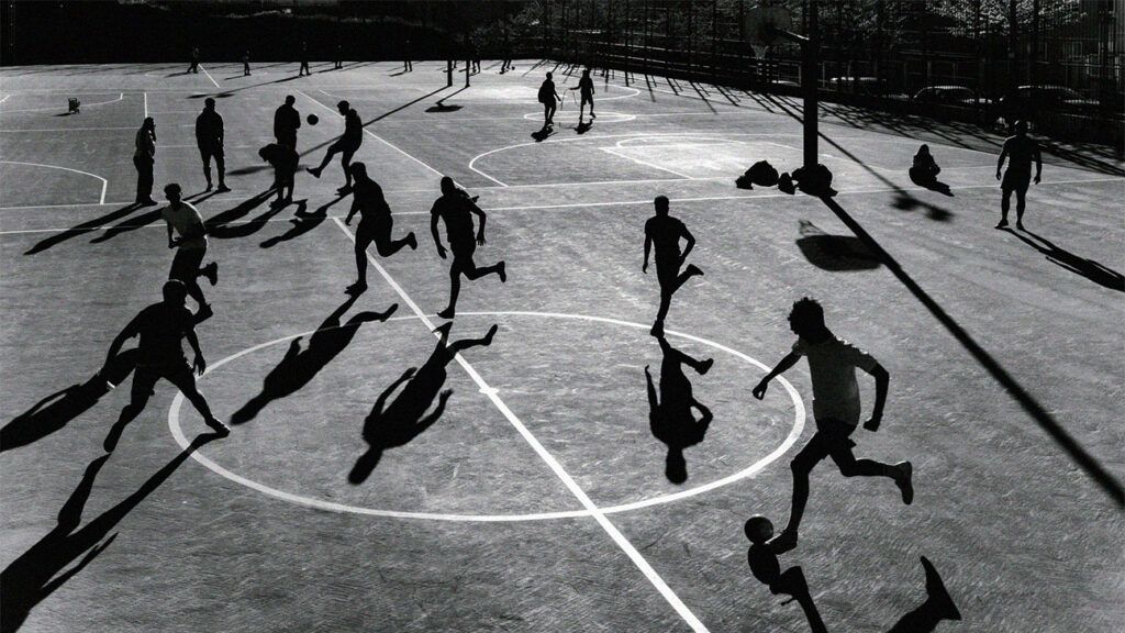 silhouettes of people running in sports court