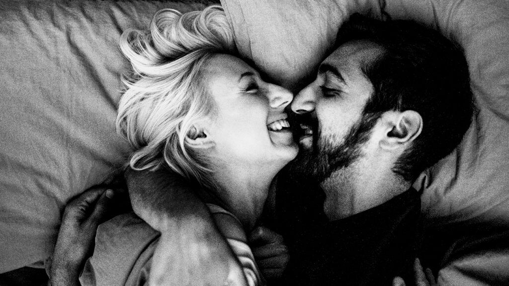 Black-and-white photo of a couple in bed.