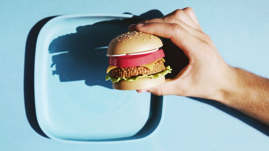 Mini fake veggie burger held in hands