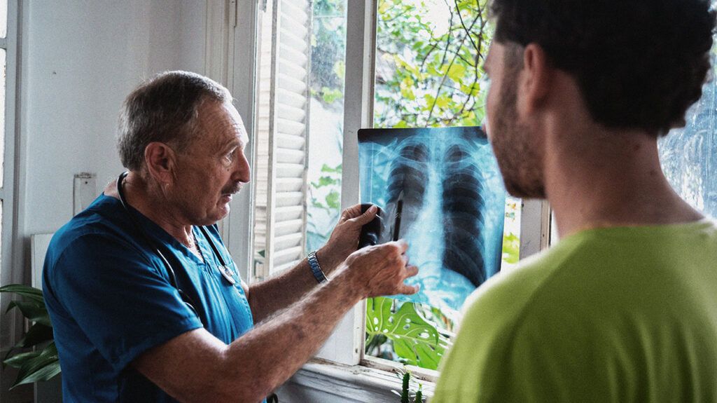 A healthcare professional explaining the x-ray results to a person who may have small cell lung cancer.