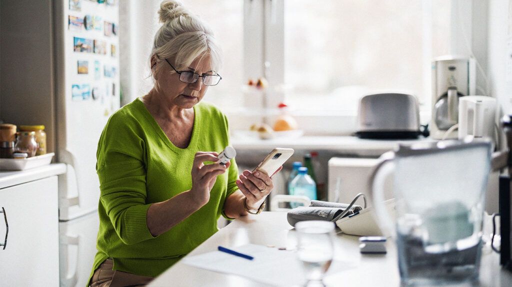 Older woman checking prescription with cell phone