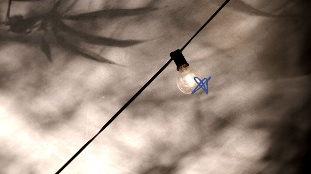 Lit lightbulb hanging on a wire
