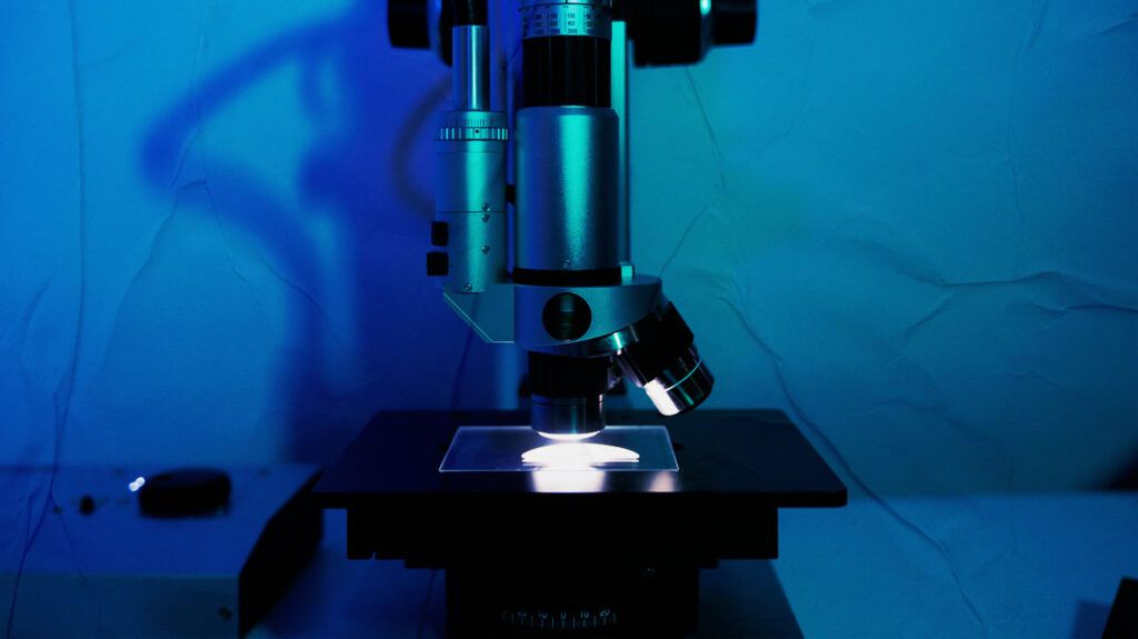 microscope and sample slide against blue background