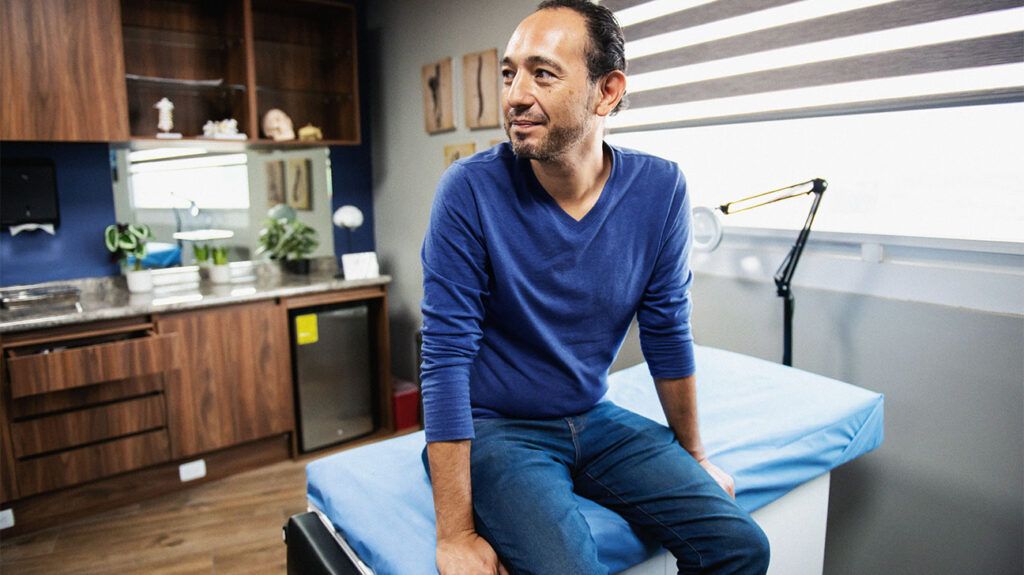 A man sitting on a bed in a doctor's office-1