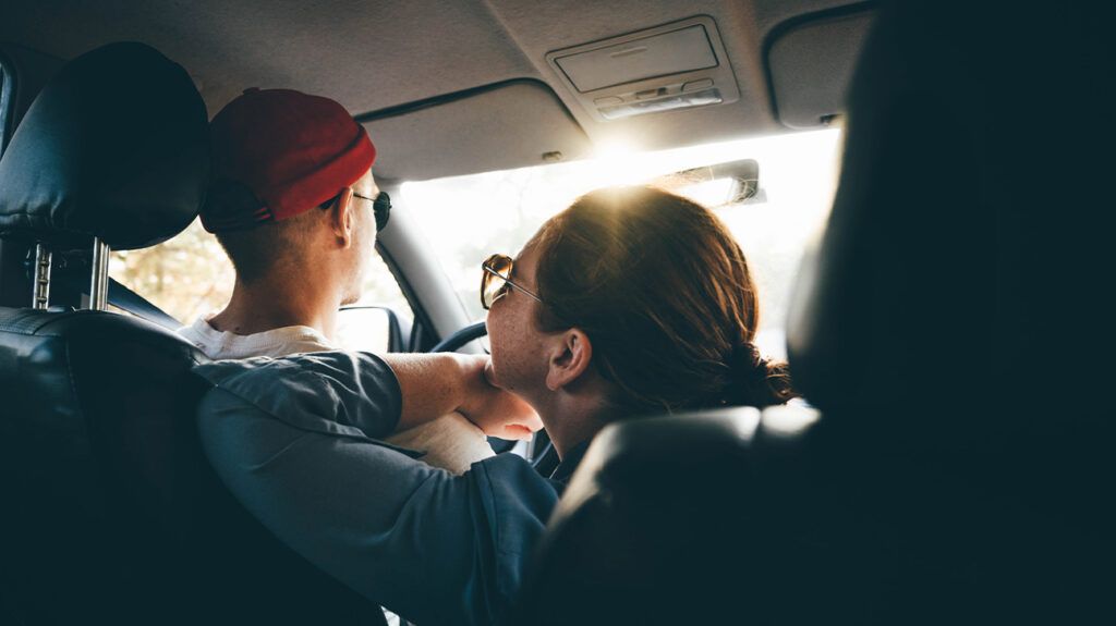 Two people in a car, gazing at each other