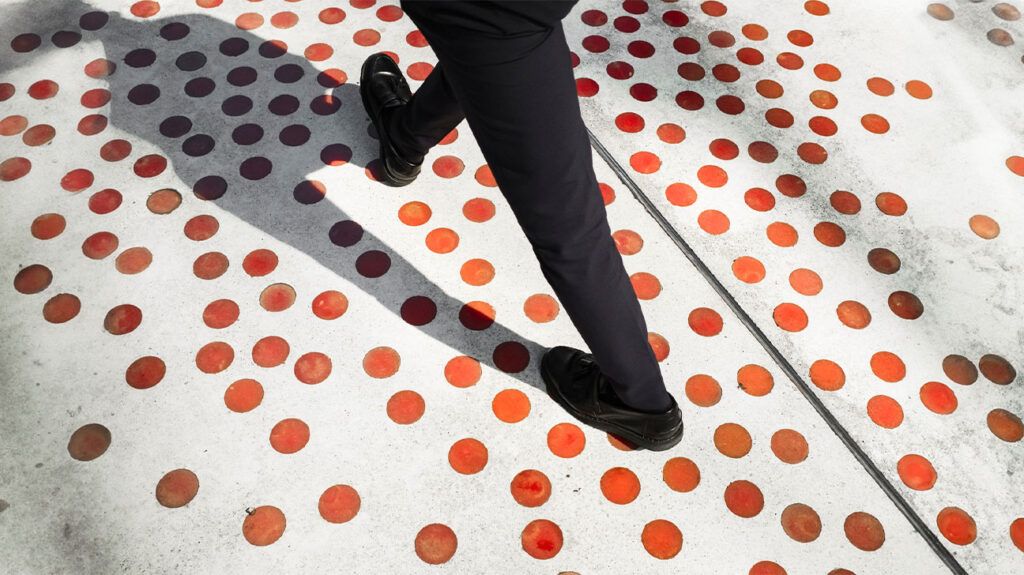A person walks on a floor covered with dots