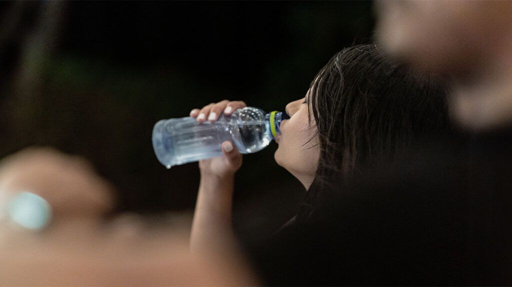 A person drinking water from a bottle 1