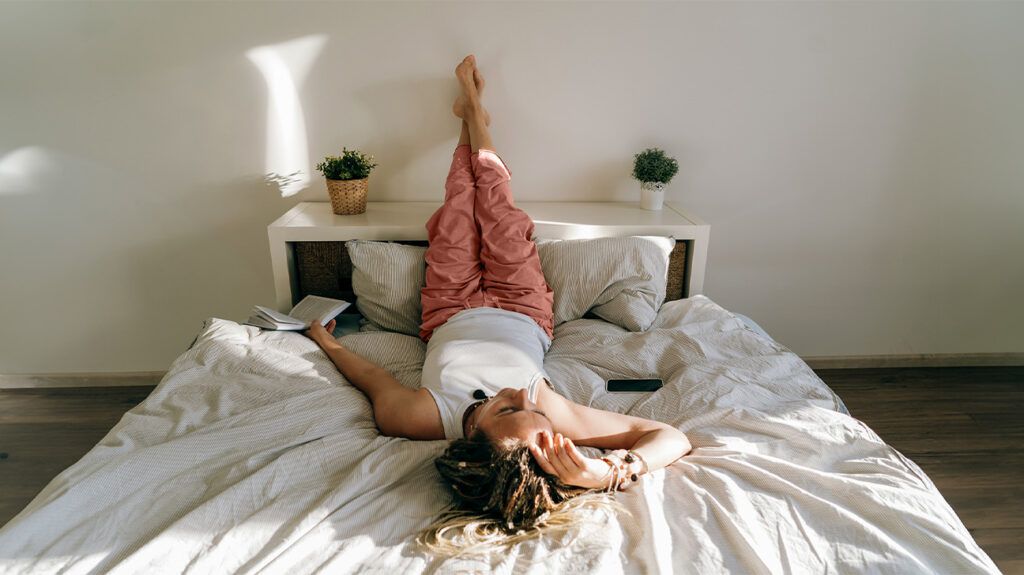 A woman elevating her legs in bed