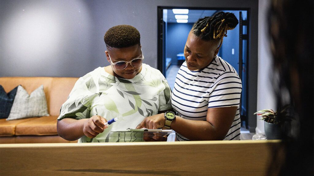 Two people are looking at a clipboard.