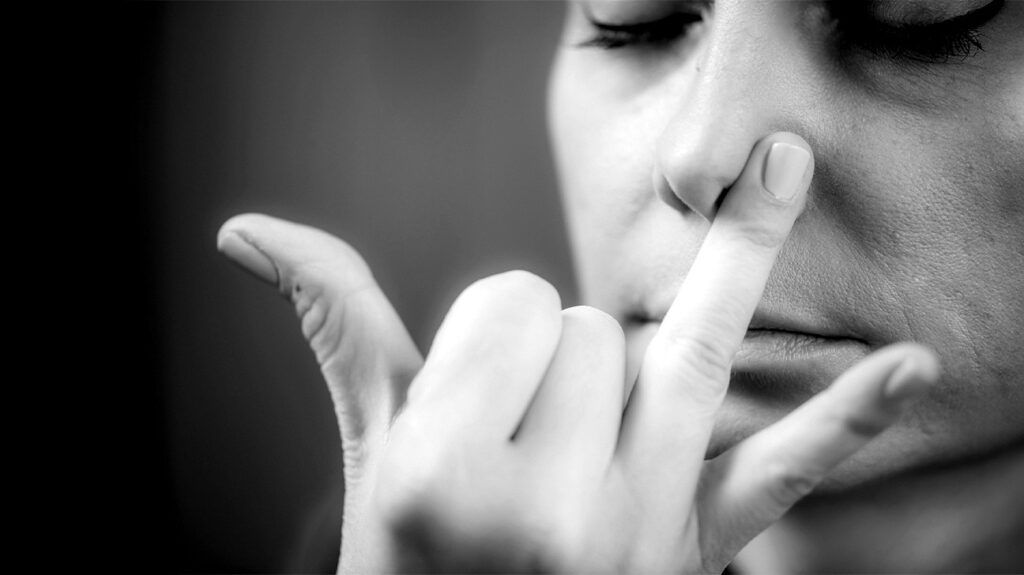 A person applying pressure to one nostril to help improve airflow.