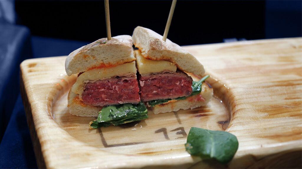 Two quarters of a cheese and beef burger side by side, held together by a toothpick each