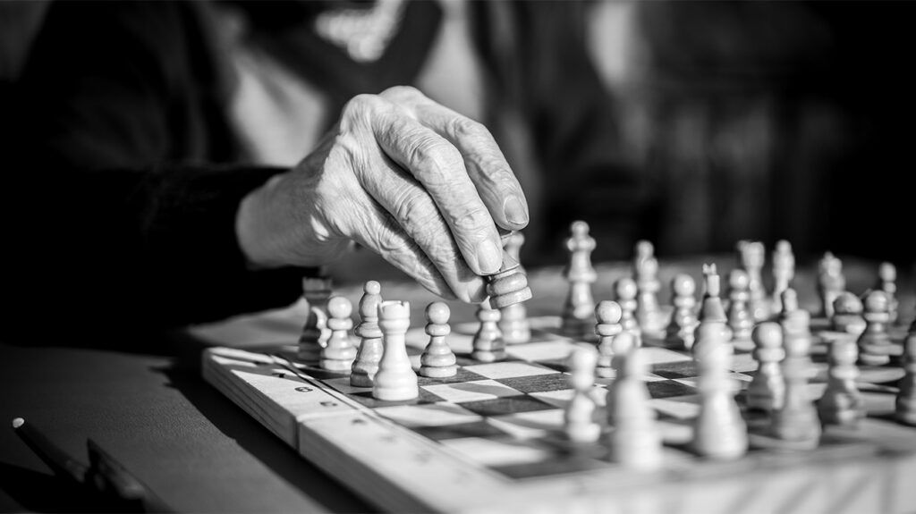 A close-up of an older adult playing a game of chess