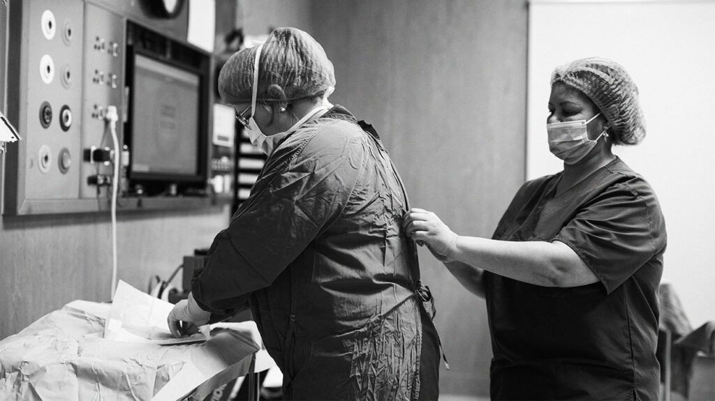 Black and white image of healthcare professionals preparing for surgery