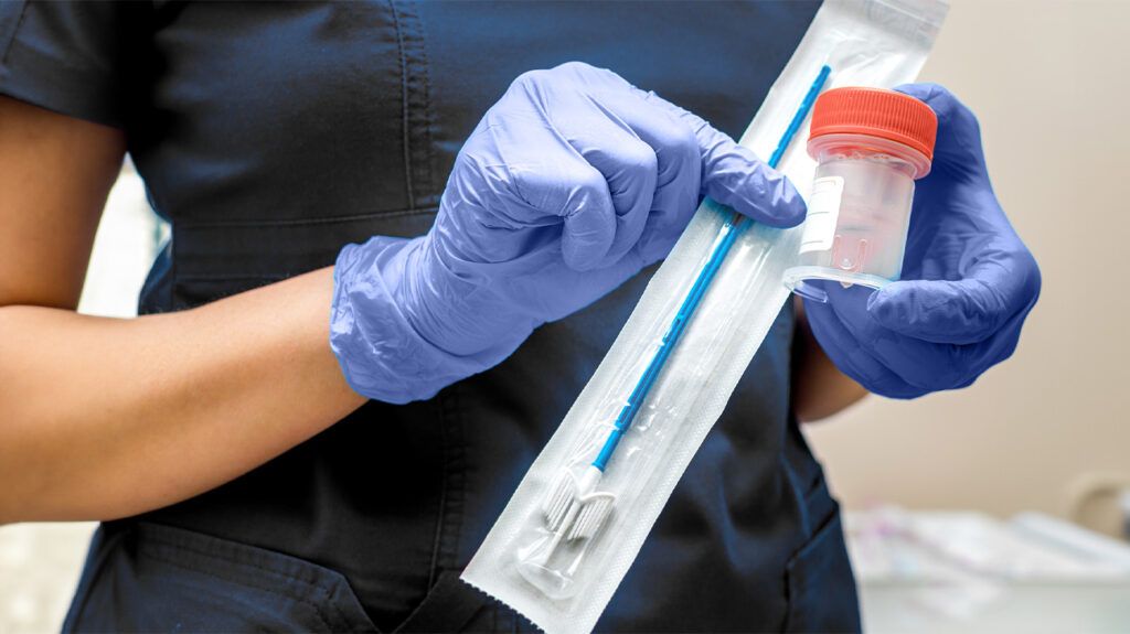 A healthcare professional holding a swab used in PAP smears, which are covered by Medicare.