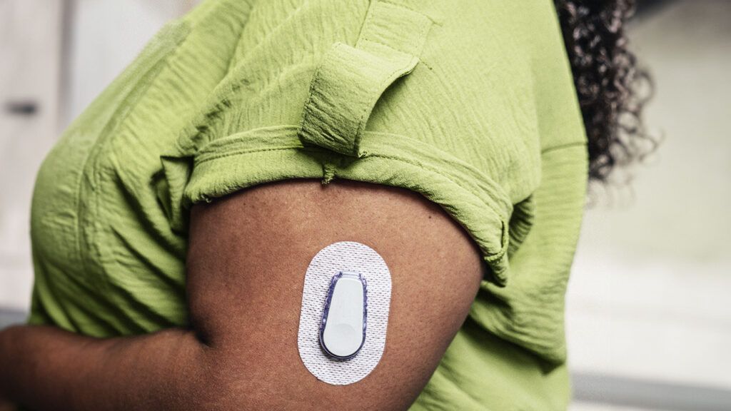 glucose monitor sensor patch on a person's arm