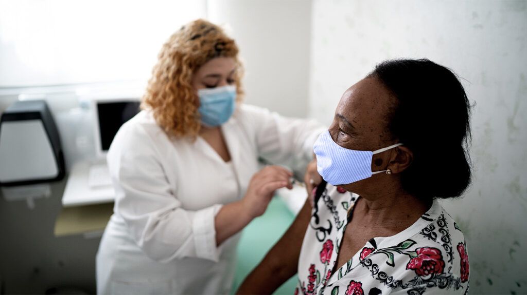 A medical professional is giving a person an injection.