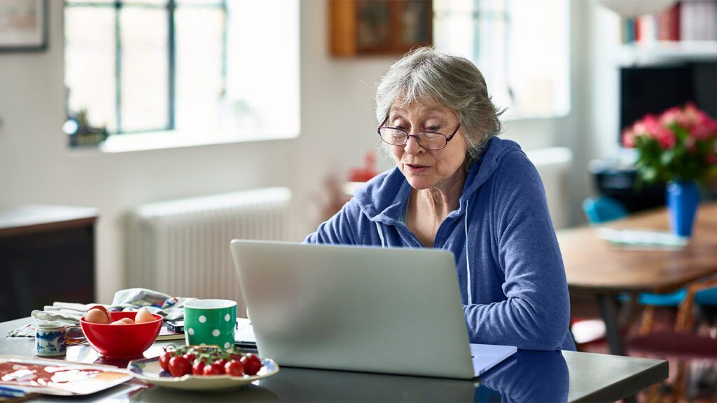 A woman using a laptop to apply for Medicare online.