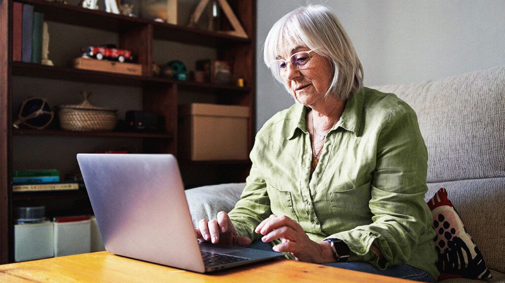 Female over 65 looking up information on a laptop