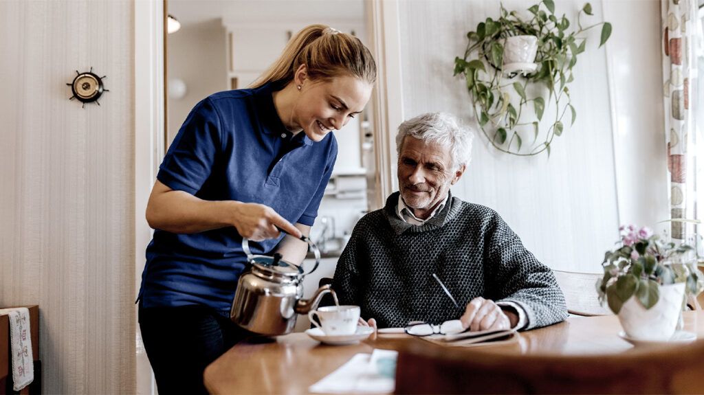 A visiting angel visiting an older man at home