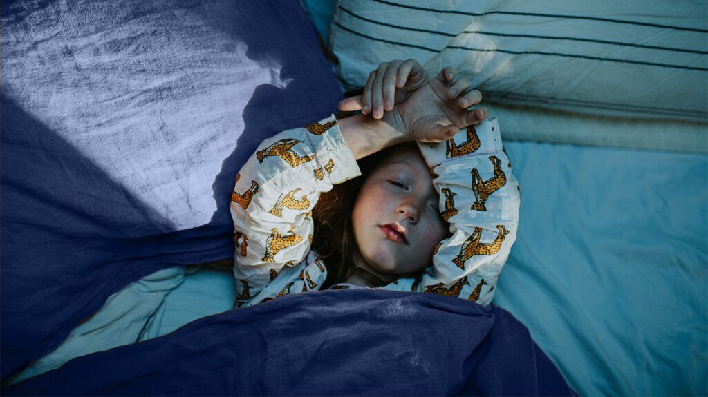 A child lying awake in bed 1