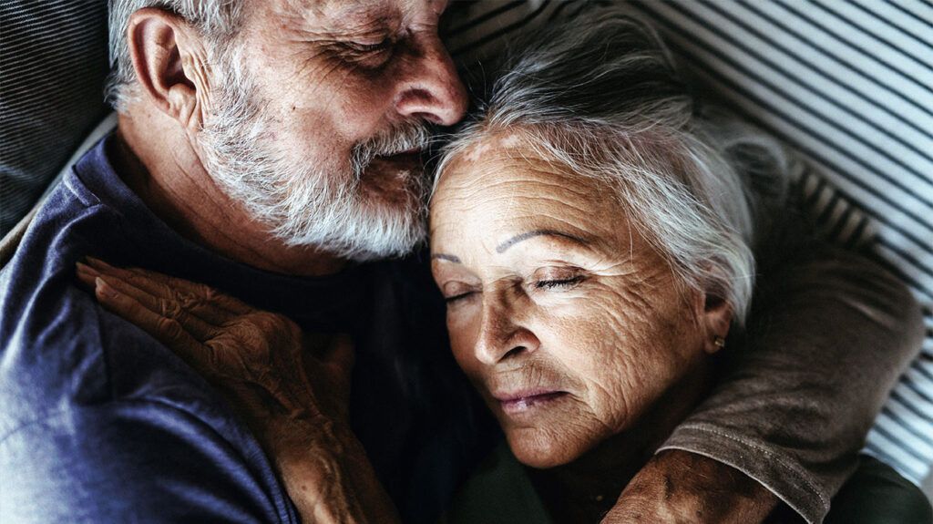 Closeup of an elderly couple with their eyes closed.