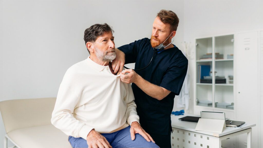 Healthcare professional giving a health check to a male over 65