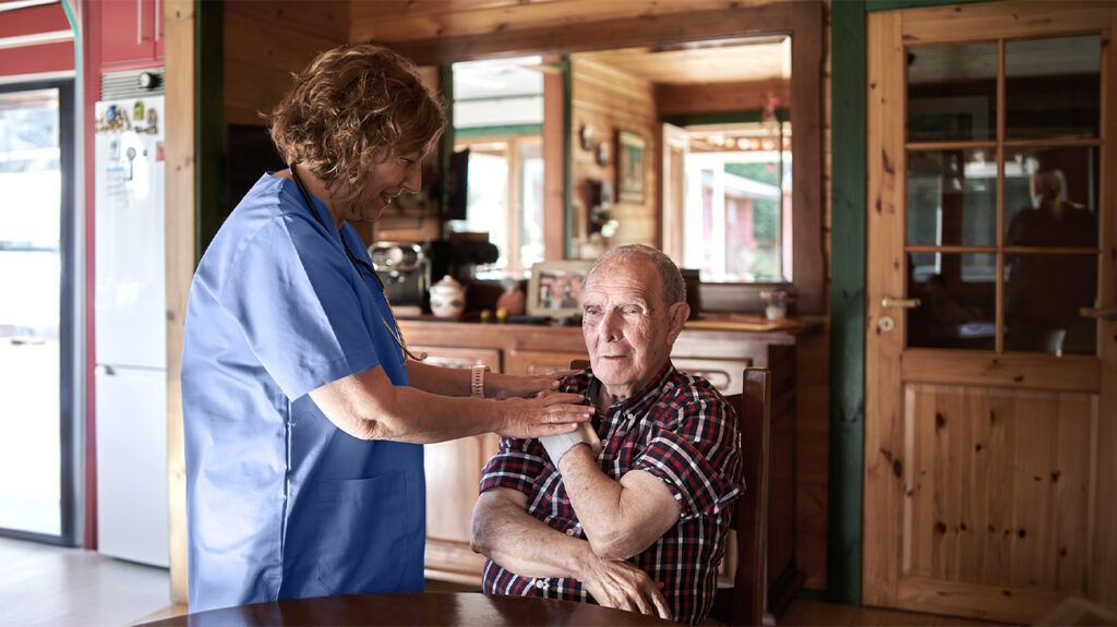 A healthcare worker visiting an older man at home