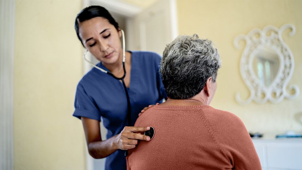 Healthcare professional checking a person's lungs with a stethoscope