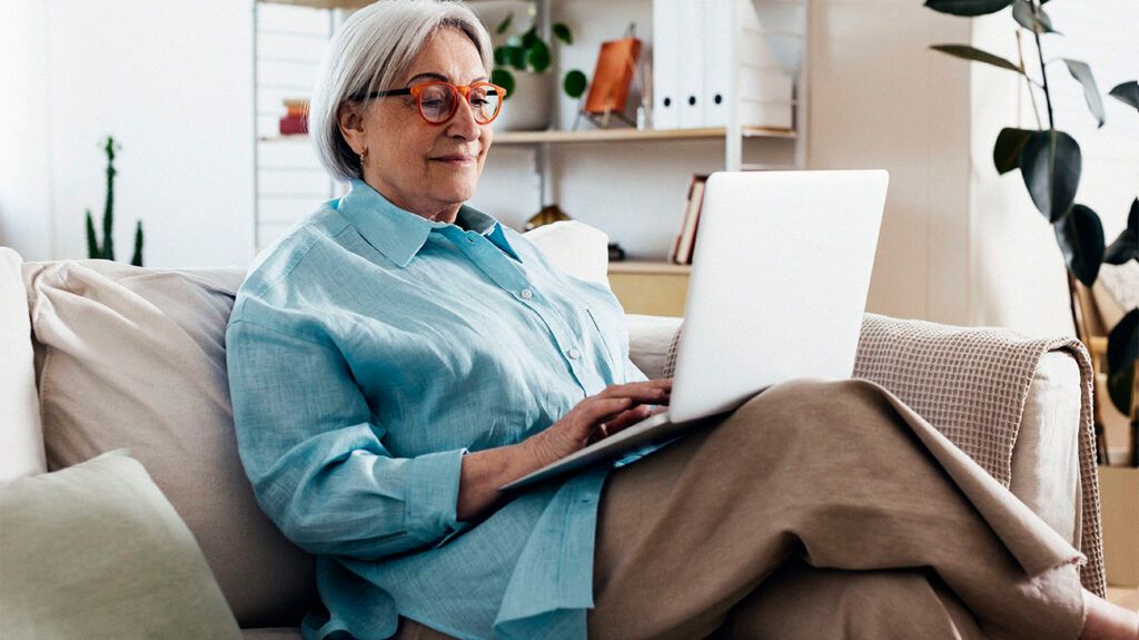 Female over 65 looking up Medicare information on a laptop