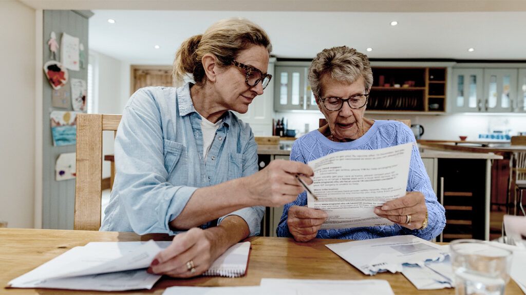 Two older adults are looking at paperwork.