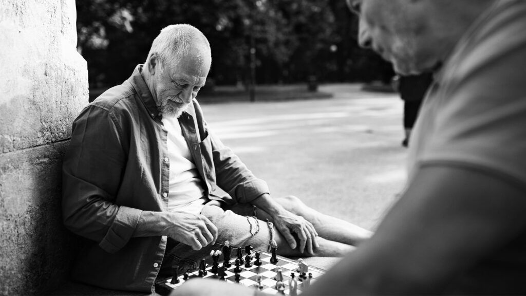 black and white photo of an older man playing chess